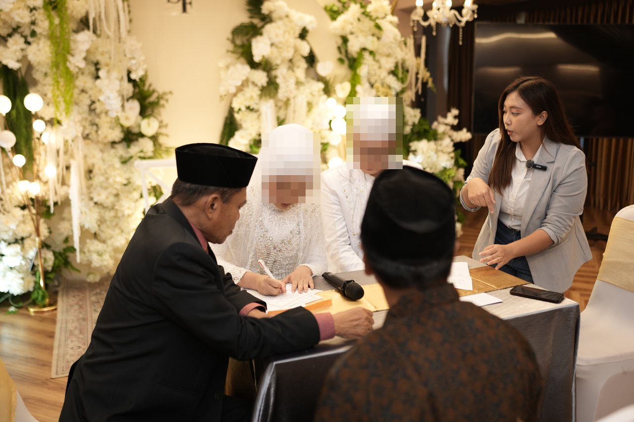 결혼식장에서 혼인 서류에 서명하는 신부와 신랑