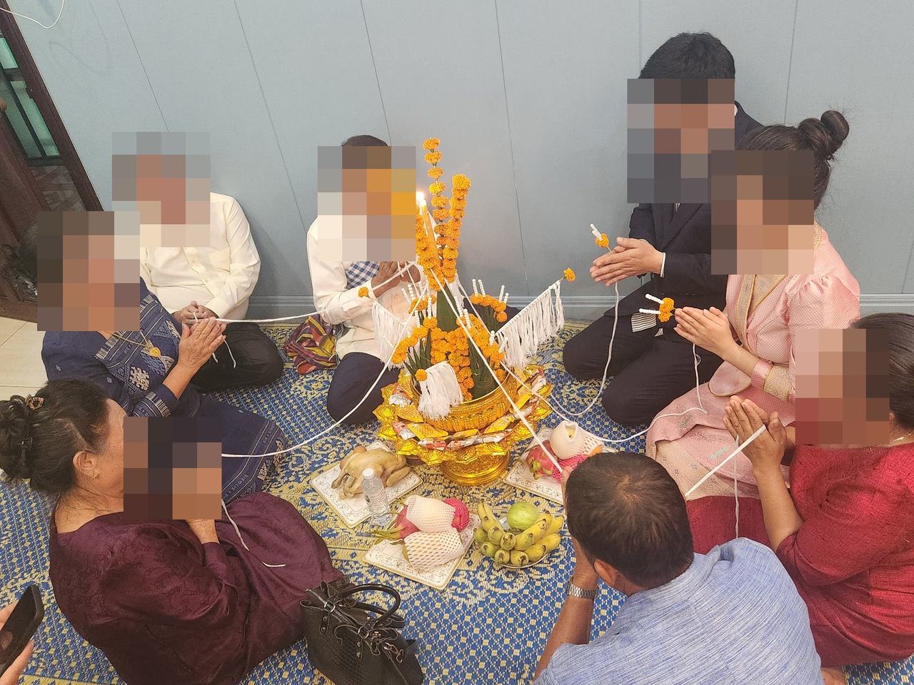 라오스 바시 의식에서 축복의 실을 묶는 모습