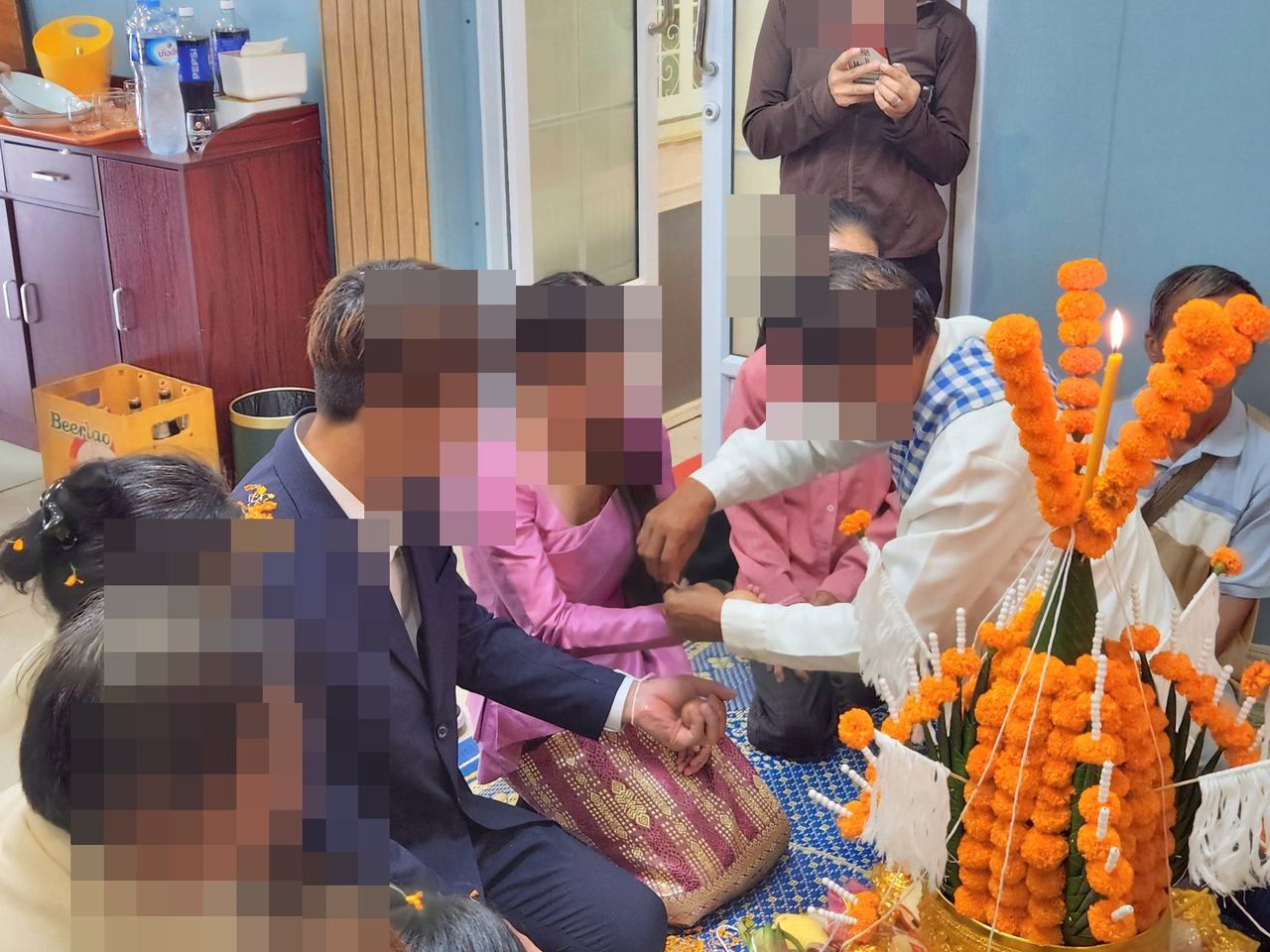 바시 의식에서 축복의 실을 묶는 모습
