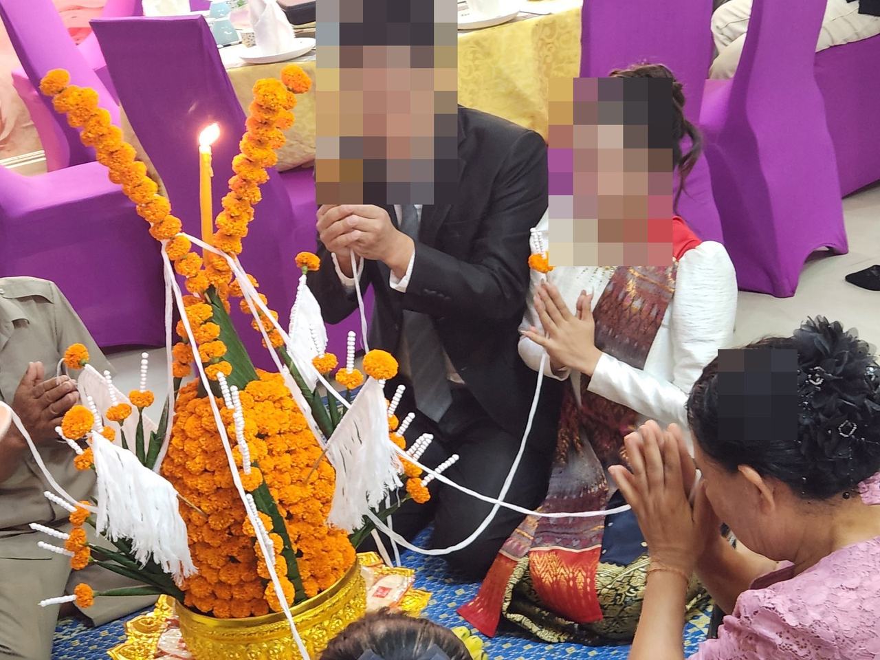바시 의식에서 촛불 앞에 앉은 신랑 신부